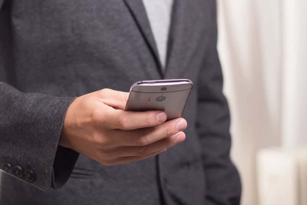 Suited businessman using business mobile phone with UK plan