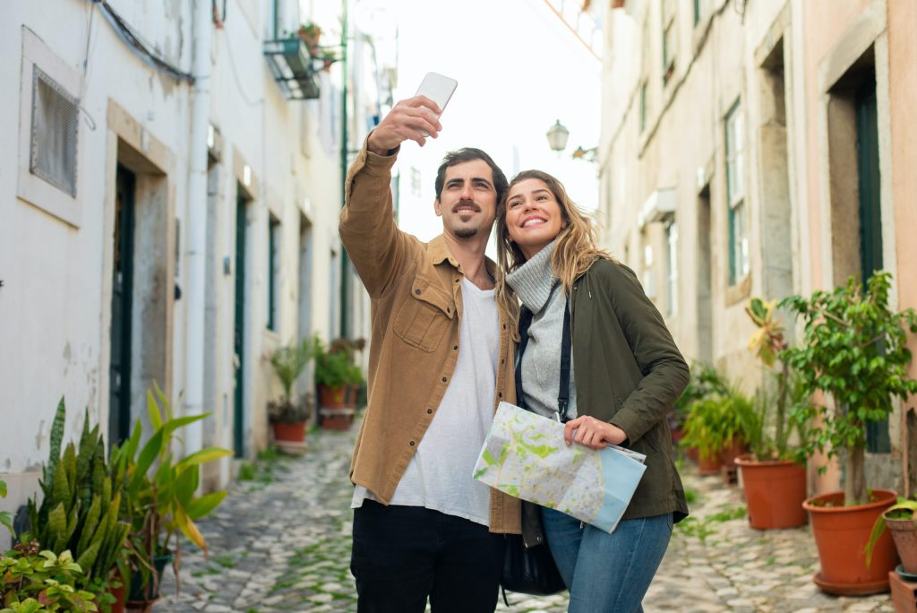 Couple taking a selfie with a map using roaming data in the EU