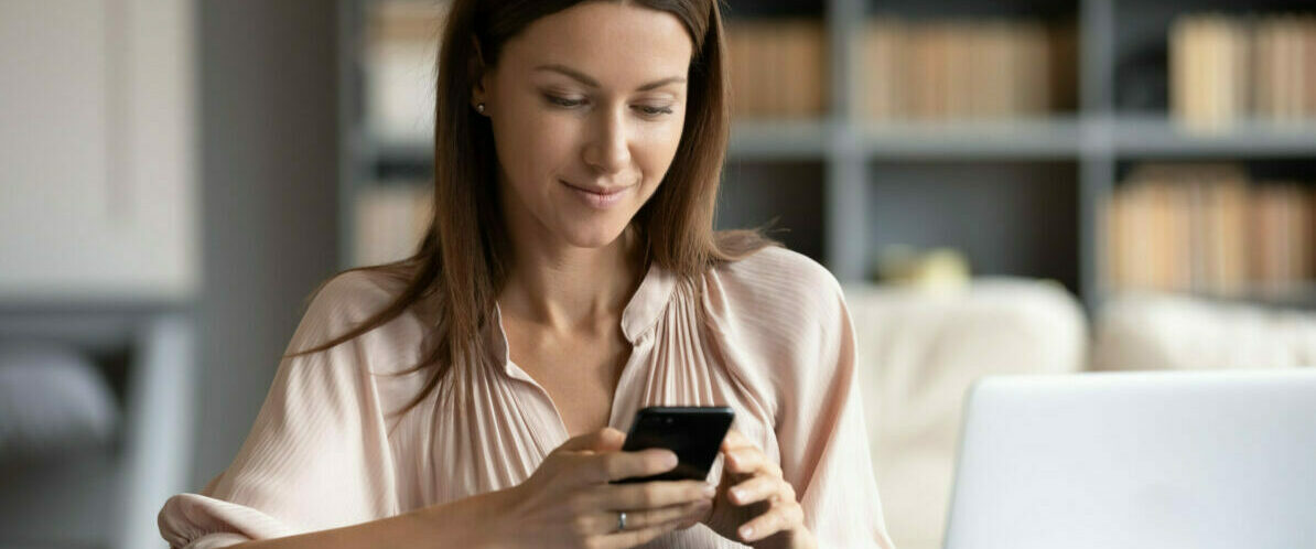 Smiling woman uses mobile for work focus apps