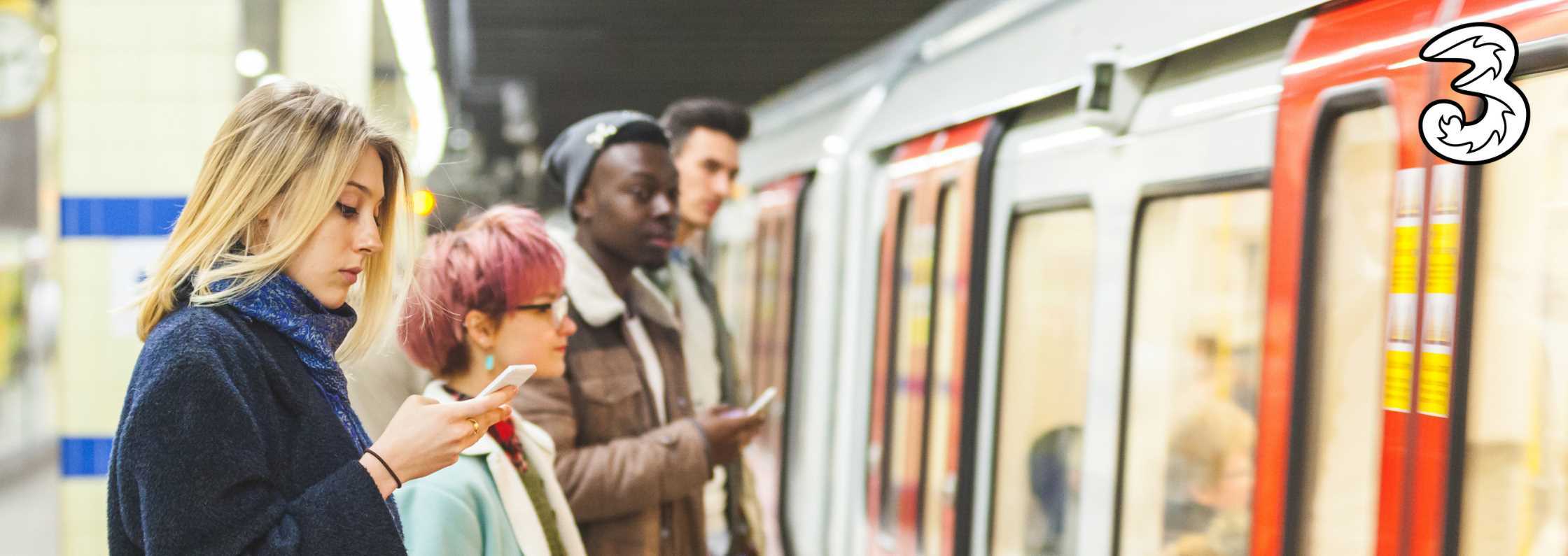 Woman waiting for train uses free London Underground WiFi from Three