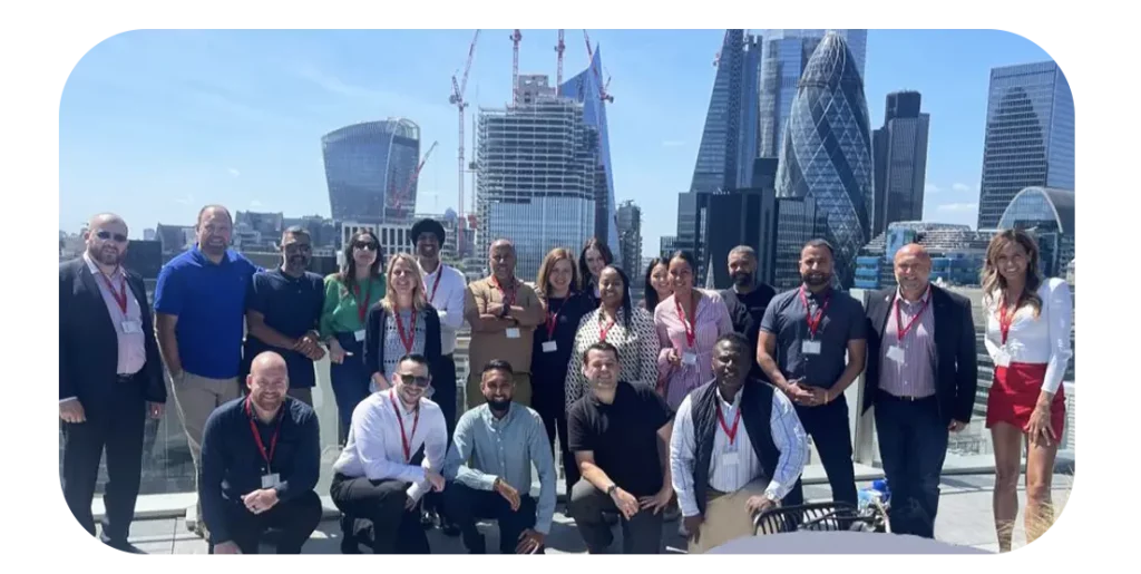 Photo of the Business Mobiles team outside of their office with London cityscape backdrop