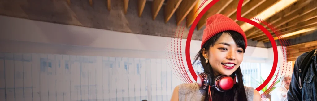 Smiling Vodafone employee sits at office desk with laptop