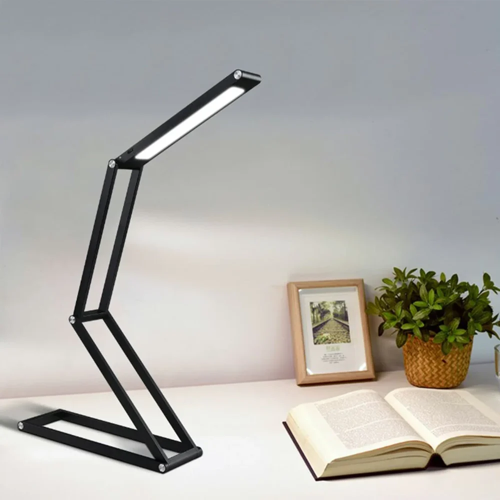LED desk light illuminates book, picture frame, and plant pot.